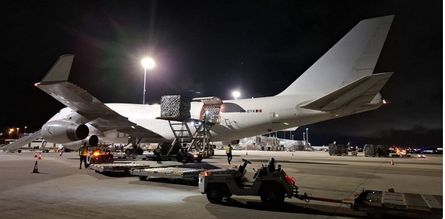 Avion cargo sur le tarmac de nuit pendant le chargement